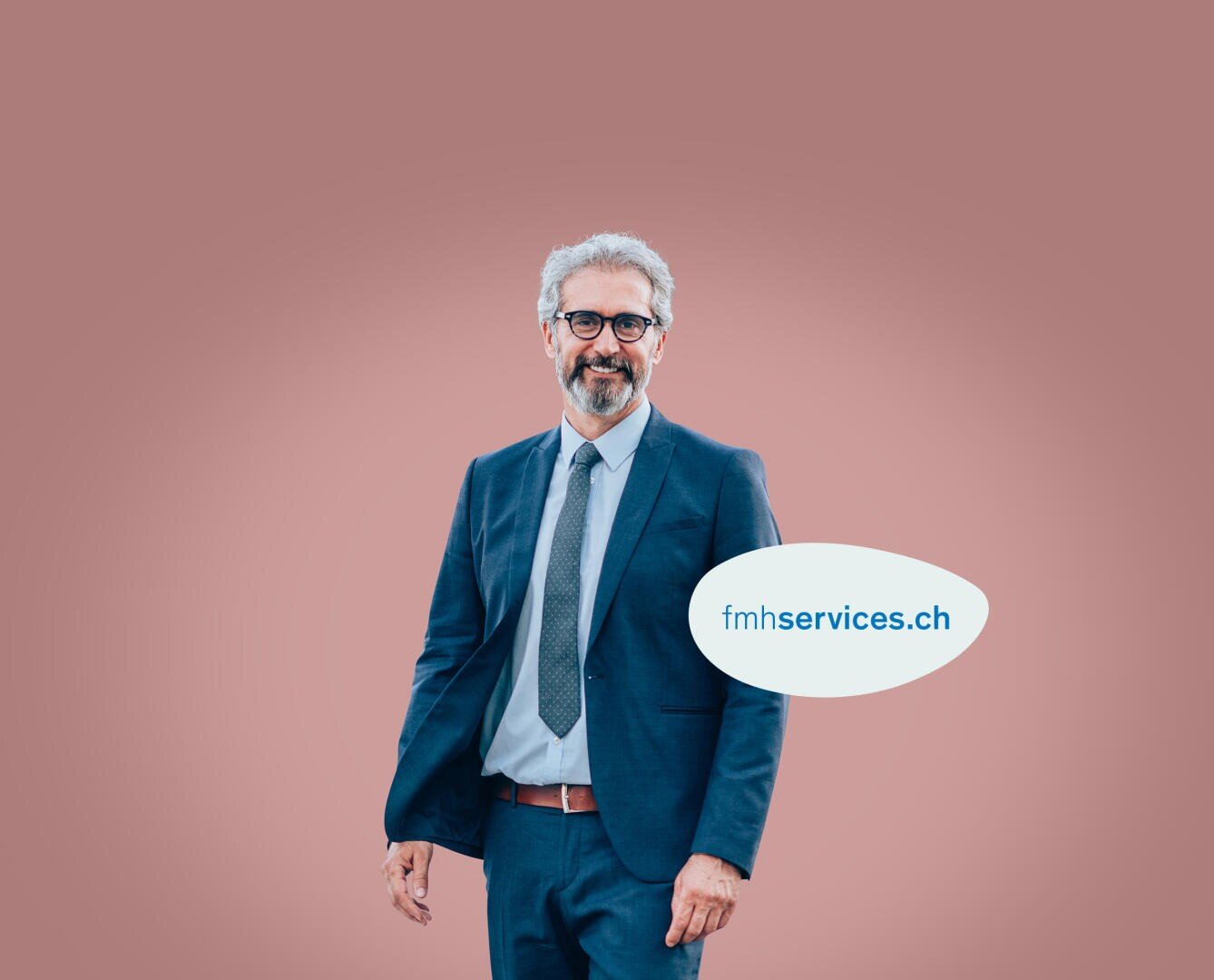 Un homme souriant, vêtu d'un costume bleu et d'une cravate, se tient devant un fond rose sobre. Une bulle à côté de lui contient le texte : fmhservices.ch.